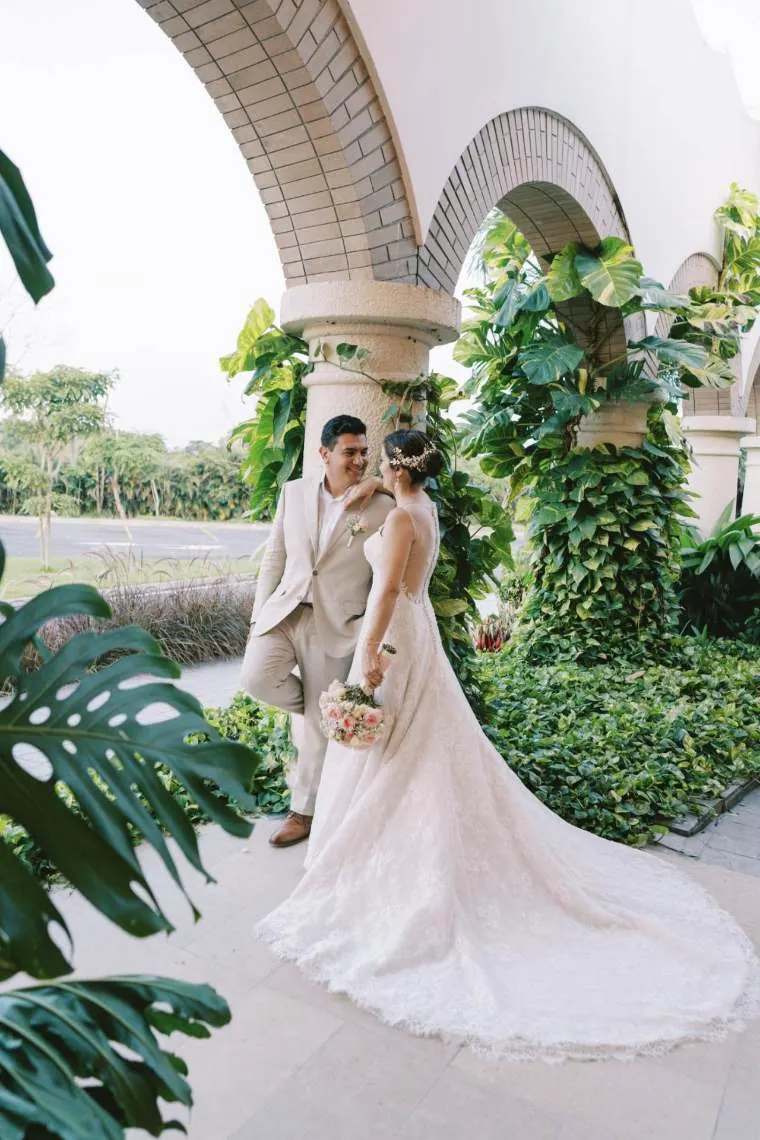 Novios tomados de la mano en la puerta de la capilla con la bóveda de madera iluminada, boda destino cerca de Bogotá