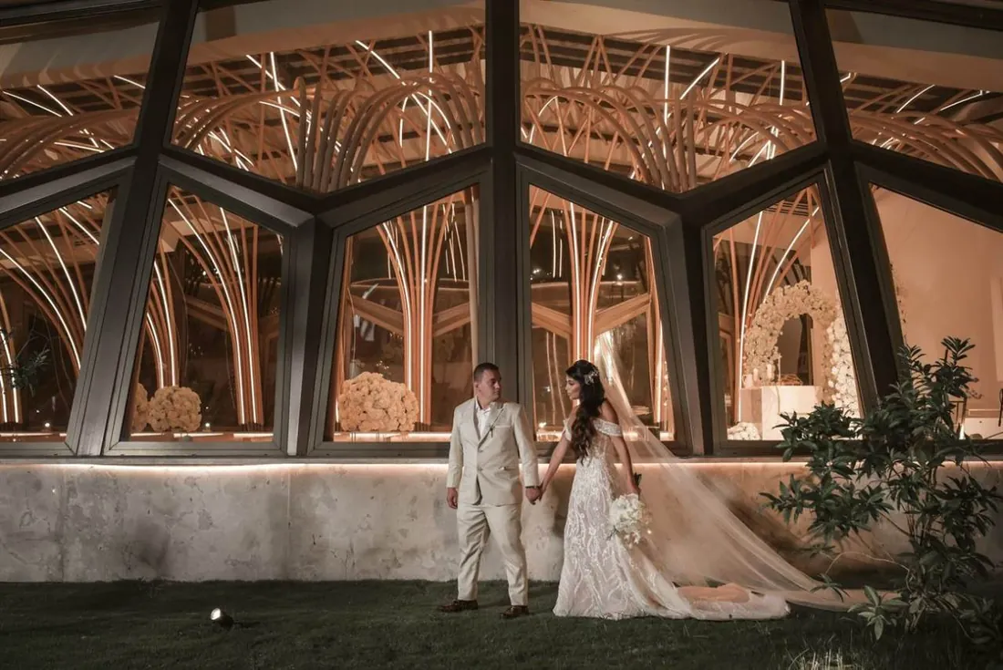 Novios frente a la capilla iluminada de Hacienda Las Marías en una boda destino de noche cerca de Bogotá