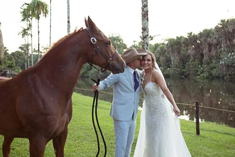 El novio besa a la novia junto a su caballo al atardecer, boda destino en los Llanos