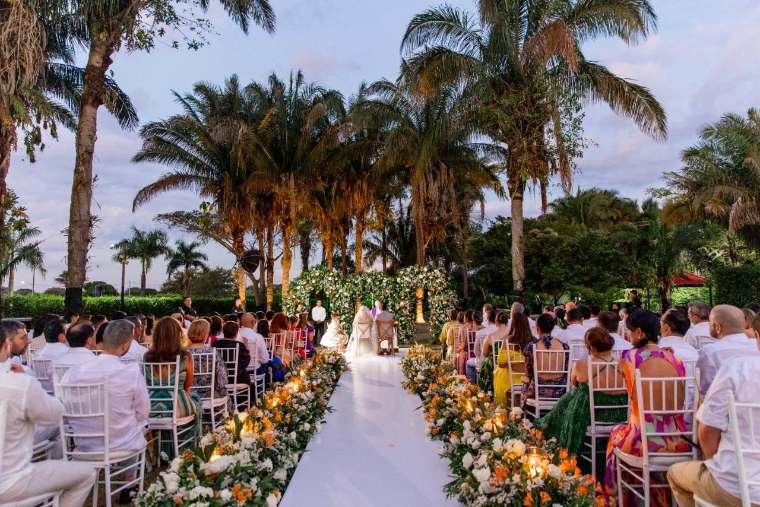 Liliana Céspedes despidiendo a los novios en un convertible blanco a la salida de una boda en Villavicencio