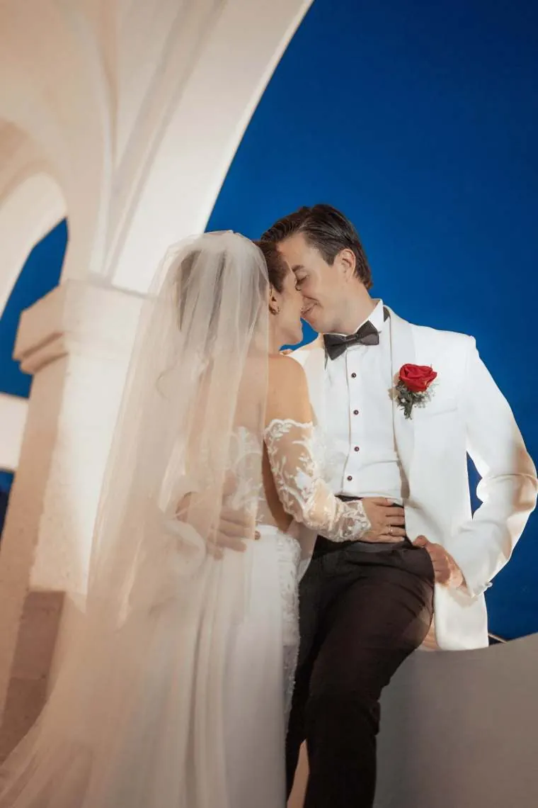 Novios besándose entre confeti a la salida de la capilla, rodeados de sus invitados, en una boda en Villavicencio