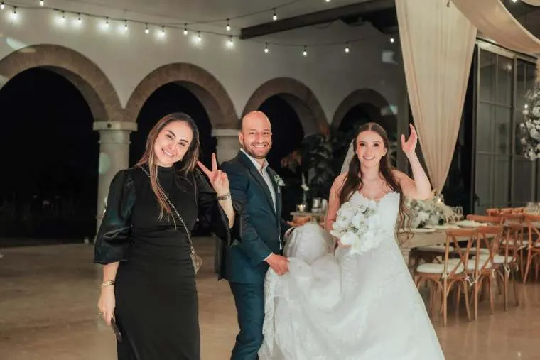 Liliana Céspedes celebrando con los novios en la recepción nocturna bajo luces, boda en Villavicencio
