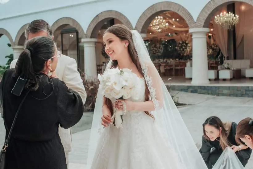 El equipo acompañando a la novia y cuidando su vestido antes de la ceremonia, bodas en Villavicencio